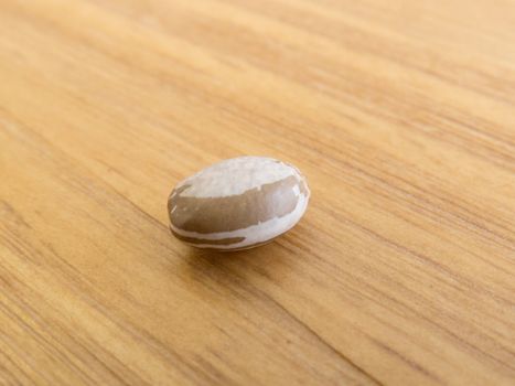A grain of carioca beans isolated, on wooden texture table.