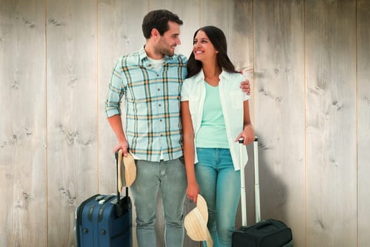 Attractive young couple going on their holidays against wooden planks