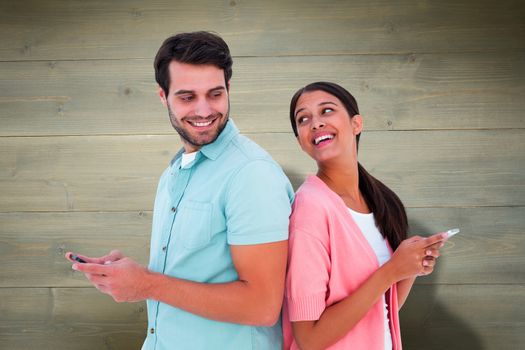 Happy couple sending text messages against bleached wooden planks background