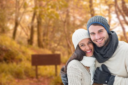 Young winter couple against tranquil autumn scene in forest
