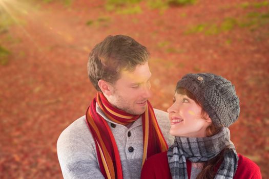 Smiling couple looking at each other against peaceful autumn scene in forest