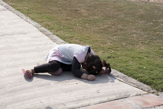 Little girl hiding her face in the ground.