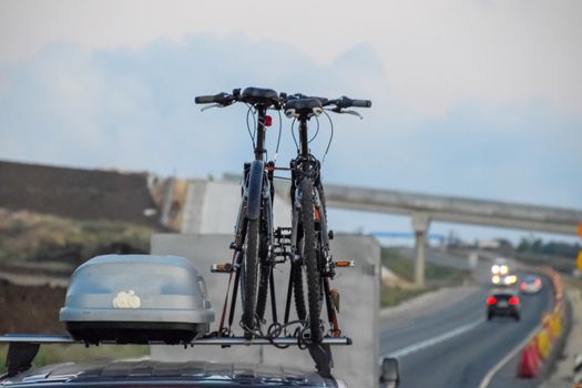 The bikes attached to the roof of the car. Travelling with bikes by car.