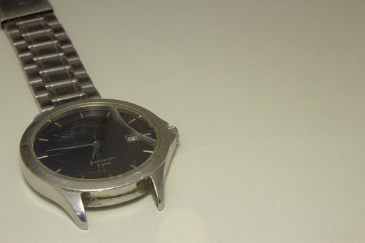 Broken wrist watch, with its glass shattered and damaged bracelet