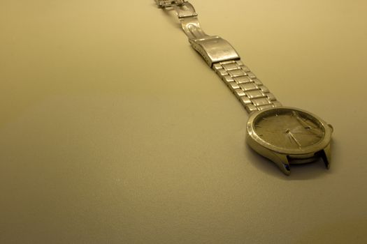 Broken wrist watch, with its glass shattered and damaged bracelet