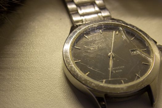 Broken wrist watch, with its glass shattered and damaged bracelet