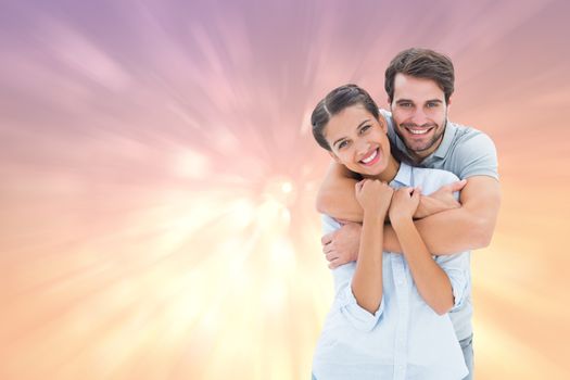 Cute couple smiling at camera against pink abstract light spot design