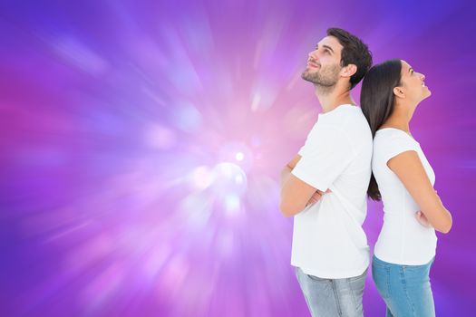 Happy couple standing looking up against purple abstract light spot design