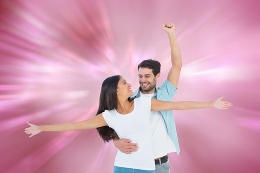 Happy casual couple cheering together against digitally generated love heart background