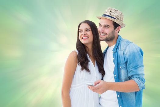 Happy hipster couple smiling together against green abstract light spot design