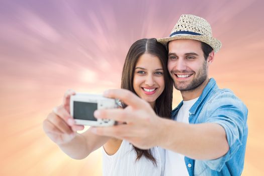 Happy hipster couple taking a selfie against pink abstract light spot design