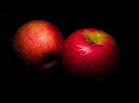 Close-up of Water droplet on glossy surface of freshness red apple on black background