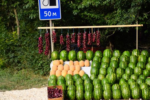 Selling vegetables and watermelons by the road. Resort shops by the road for tourists.