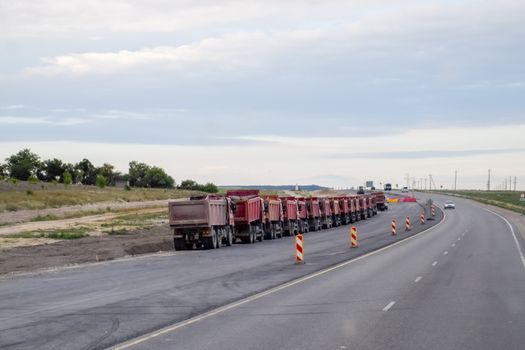 Tipper trucks are standing on the side of the road. Crimean peninsula.