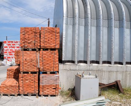 Warehouse of building materials. a Building base, metal, wood and blocks with bricks.