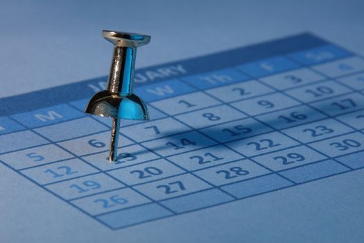 A push pin in calendar with blue light