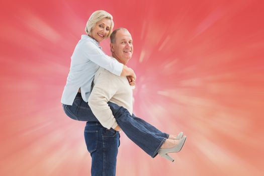 Happy mature couple having fun against red abstract light spot design
