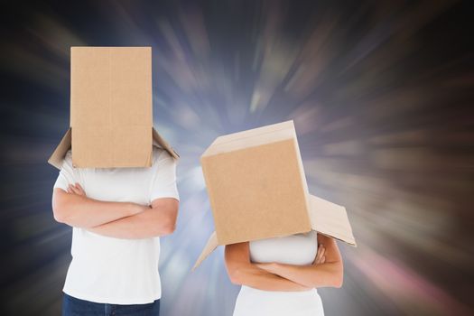 Mature couple wearing boxes over their heads against dark abstract light spot design