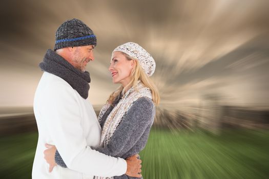 Happy couple in winter fashion embracing against stormy sky over city
