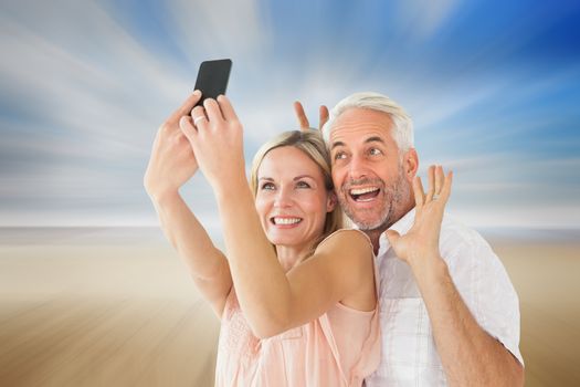 Happy couple posing for a selfie against serene beach landscape