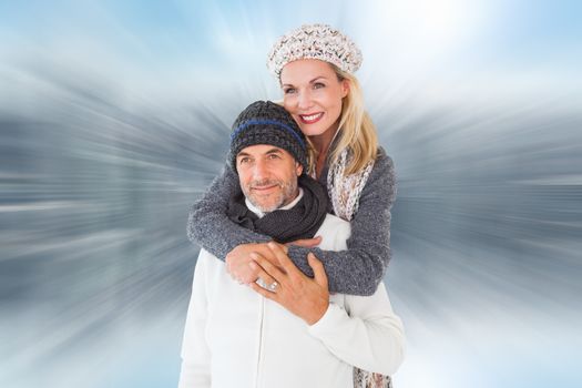 Happy couple in winter fashion embracing against room with large window looking on city