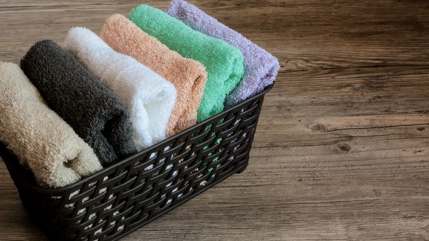 colorful towels in a basket on a wooden table