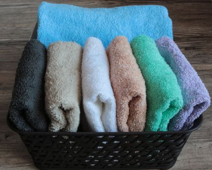 colorful towels in a basket on a wooden table