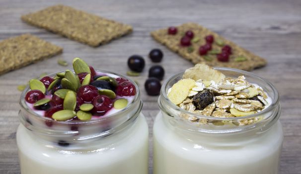 Greek yogurt, milk, smoothies, blueberries and currants in a glass jar on a wooden table, detox, diet