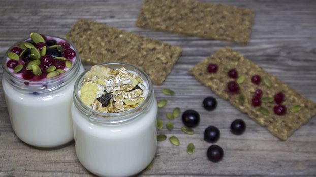 Greek yogurt, milk, smoothies, blueberries and currants in a glass jar on a wooden table, detox, diet