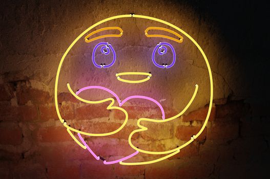 3d rendering  , Neon sign background " Care Emoji " Sign hanging on a wall and lit brightly.