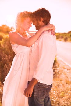 Attractive couple embracing by the road on a sunny day