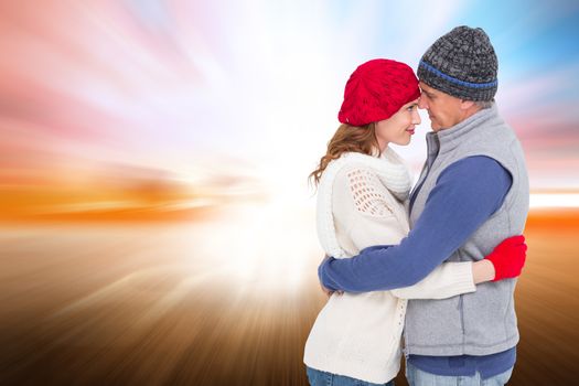 Happy couple in warm clothing hugging against field with light wave