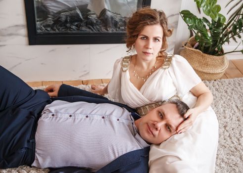 newlyweds are lying on the carpet in front of the fireplace indoor closeup
