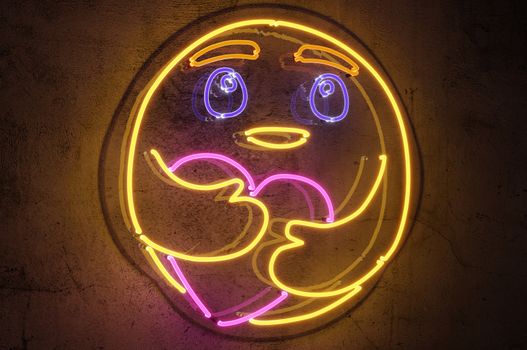 3d rendering  , Neon sign background " Care Emoji " Sign hanging on a wall and lit brightly.