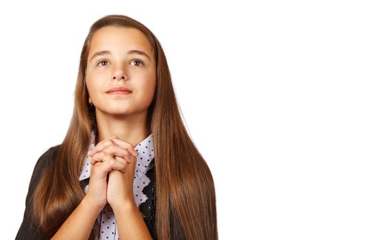 portrait of teen brunette girl looking up with clasped hands on white