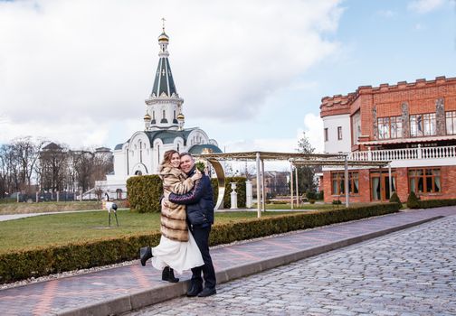 newlywed couple on walk in the city park on early spring day