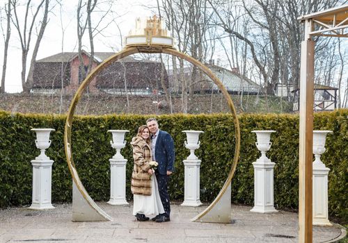 newlywed couple on a walk in the park on early spring snowy day