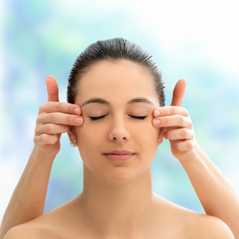 Close up face shot of young woman at alternative medicine session.Therapist touching side of woman’s head.