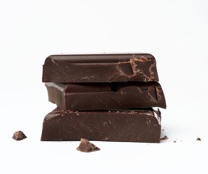 stack of pieces of black chocolate on a white background, delicious dessert and ingredient for cooking