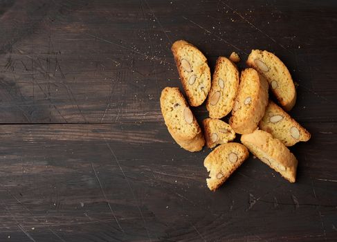 baked piece Italian almond biscotti, cantuccini cookies, traditional italian Christmas, New Year dry cookies. baking on a brown wooden background, copy space