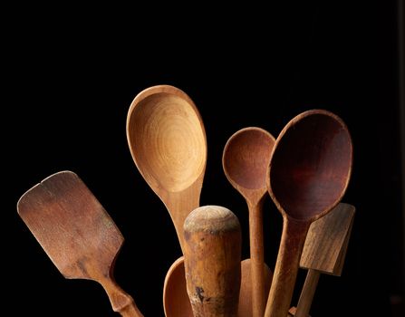 various spoons and kitchen wooden utensils, black background 