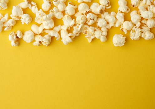 white delicious popcorn on a yellow background, place for an inscription, snack while relaxing, flat lay