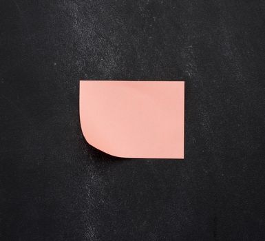 blank pink paper pink sticker glued on black chalkboard, place for inscription