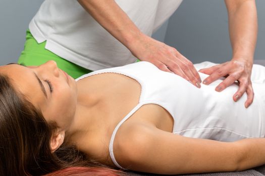 Close up of little girl at osteopathic treatment session. Therapist doing belly massage on child. 
