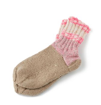 pair of striped handmade knitted warm socks made of sheep’s wool yarn, pink clothing is isolated on a white background