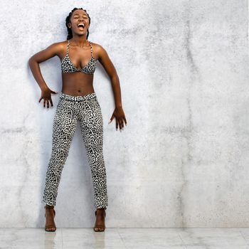 Full length portrait of screaming african woman against concrete wall.Young girl dressed in leopard skin pants and bikini top.