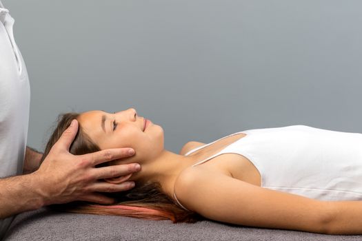 Close up of child having reiki treatment.Male therapist touching girl’s head restoring emotional well being.