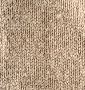 fragment of knitted fabric from light brown wool of a sheep, pigtail pattern