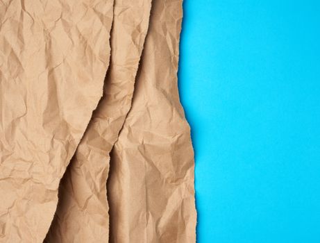 background of layered brown torn paper with a shadow on a blue background, backdrop and template for designer, copy space