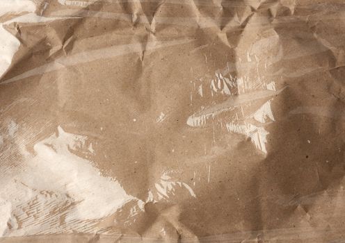 texture of a transparent stretching plastic film for packaging products on a brown paper background, full frame, close up
